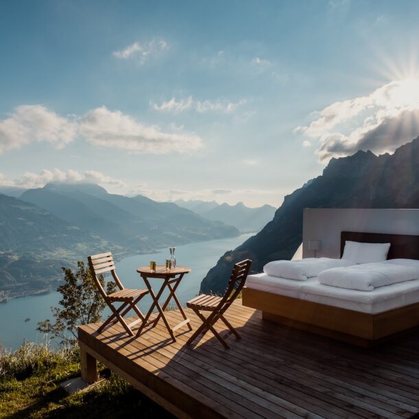 A cozy outdoor bed under a canopy, overlooking a scenic mountain landscape, suggesting a perfect setting for romantic resorts in Pakistan.